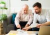 Offering Financial Help to an Elderly Loved One Without Making It Awkward Caring son doing the finances of his elderly father